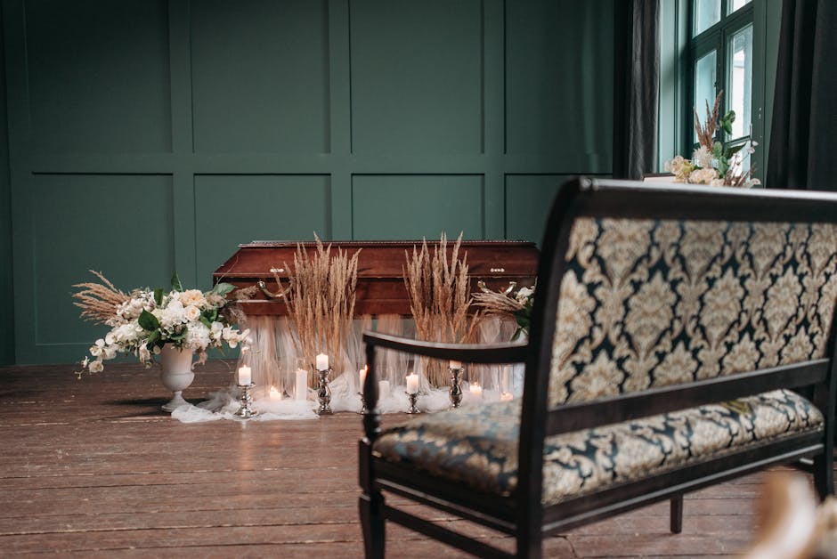 An elegant indoor setting featuring a polished wooden table against a dark green paneled wall. On the table, two symmetric floral arrangements are displayed in white ceramic vases, comprising white ro