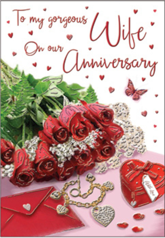A rich anniversary tableau unfolds like a story told in flowers and keepsakes, set against a softly lit background that could easily belong to a stylish flat just off High Holborn. At centre stage, a bouquet of classic red roses is gathered with deliberate care, each bloom luxuriously full and perfectly shaped, velvet petals layered like folded satin. Lush green foliage frames the roses, lending a sense of natural abundance similar to the greenery in nearby Red Lion Square, and guiding the eye gently around the image. The stems are elegantly wrapped, suggesting a hand-tied arrangement delivered fresh that morning, then laid across an anniversary card whose scripted message curls gracefully along its surface. Nearby, a vivid red jewellery box, smooth and almost velvety in appearance, hints at treasured gifts and romantic surprises, while a jewellery set glows softly beside it, catching the light with glints of gold and perhaps tiny stones. Heart motifs appear throughout-on the box, around the card, and in scattered decorative pieces-creating a rhythmic pattern that reinforces the theme of long-lasting love. Delicate lace or fine fabric edges peek into view, adding gentle texture and a sense of intimacy, like a favourite table runner brought out only for special occasions. The palette is rich with crimson, deep ruby, warm cream, and soft hints of green, with subtle shadows adding depth so each element feels tangible and close. Everything in this composition speaks of years shared together-anniversaries marked quietly at home, thoughtful surprises ordered from a trusted Holborn florist, and the steady comfort of a relationship that continues to feel both romantic and reassuringly familiar.