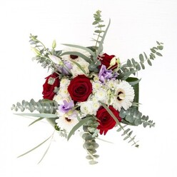 Created by experienced hands in Holborn, this floral arrangement embodies quiet confidence and modern artistry. The expressive deep red roses, their petals gently spiraled, lie at the core-a symbol of lasting affection and significant moments. Framing these, the white gerbera daisies present their creamy white petals and stark brown centres, resembling the architectural details that define much of Holborn's historic character. Sprays of soft lilac lisianthus add a cool, contemporary touch, evoking the gentle transitions of dusk over Russell Square. Fine sprays of white filler flowers give the bouquet cloud-like fullness and create gentle transitions between bold blooms. Overarching the entire piece, stems of eucalyptus stretch with silvery-green elegance, releasing a fresh aroma that alludes to outdoor mornings along High Holborn. At the base, broad, dark green leaves are carefully folded to frame the arrangement, their sheen echoing the polish of an inviting lobby or freshly swept doorstep. Visible through the vase's crystal-clear sides, straight green stems immerse in water, a subtle testament to the freshness guaranteed by local delivery. This bouquet's versatility makes it suitable for commemorating milestones, sending sympathy, or gracing a reception desk in Holborn-an arrangement where every detail is thoughtfully composed to evoke both artistry and heartfelt sentiment.