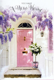 This image captures a serene Holborn doorway transformed into a floral embrace, as if the whole street has paused to welcome someone home. Overhead, wisteria drapes in generous cascades of lavender and soft purple, each cluster of blooms tumbling down in loose, fragrant strands that soften the crisp lines of the whitewashed wall. The front door, painted a gentle pink reminiscent of a faded townhouse near Chancery Lane, provides a warm focal point, its pastel tone echoed in a single shutter pulled back to let in the light. Sunlight settles over the scene in a calm, golden wash, just enough to bring out the subtle texture of the plaster and the grain of the door while leaving cool shadows at the base of the step. Nestled right at the threshold stands a stylish grey bucket, slightly industrial in feel, yet tenderly filled with a lush arrangement of white and cream roses. Each rose head is full and velvety, some just beginning to unfurl, surrounded by sprigs of soft green foliage that add depth and a touch of movement. Around the bucket, a pale pink ribbon has been tied with a relaxed, flowing bow, its colour in perfect harmony with the door behind it. You can almost imagine pausing on your way back from the office on High Holborn, catching the scent of roses mixed with the airy perfume of wisteria, and feeling that gentle surge of optimism that comes with a new address. The scene is calm yet quietly celebratory, perfect for marking a housewarming or congratulating someone on a new start in the heart of Holborn.